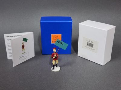 une petite figurine représentant un homme tenant un drapeau