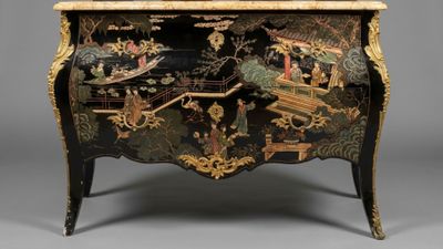 a black and gold chest with a painting on it