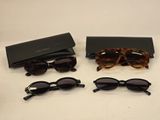 three pairs of sunglasses and a case on a table