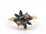 a close up of a gold ring with blue sapphires and diamonds