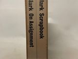 two books are stacked on top of each other on a white surface