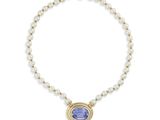 un collier orné d'une pierre bleue et de perles sur fond blanc
