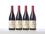 three bottles of red wine sitting on top of a table