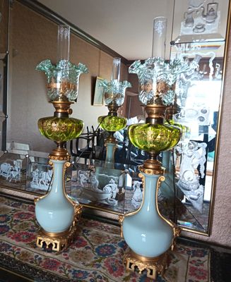 deux vases verts posés sur une table devant un miroir