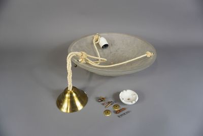 une assiette blanche ornée d'une clochette dorée et de quelques boutons