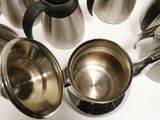 a lot of coffee pots and cups on the counter