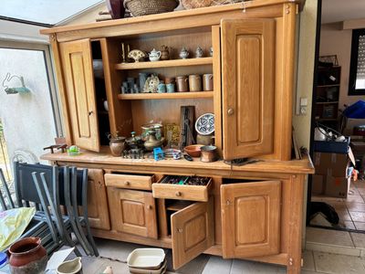 une grande armoire en bois sur laquelle sont posés de nombreux plats