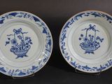 deux assiettes bleues et blanches ornées de fleurs sur un fond noir