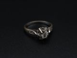 a close up of a diamond ring on a black surface