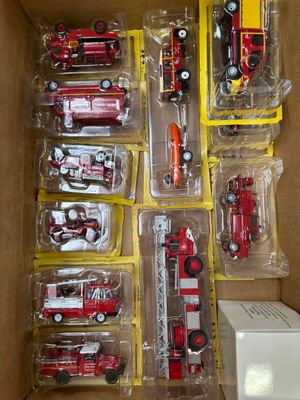 une boîte contenant tout un tas de camions de pompiers miniatures