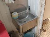 un lavabo dans un coin de la salle de bains, avec des toilettes rouges