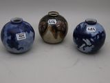 trois vases bleus et blancs posés les uns à côté des autres sur une table