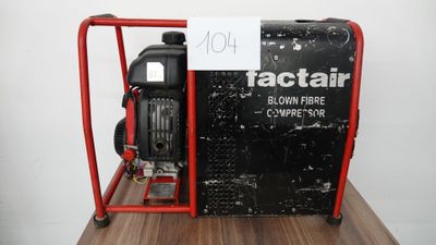 une petite machine noire et rouge posée sur une table en bois