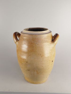 un vase marron muni de deux anses, sur un fond blanc