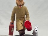 a figurine of a man with a suitcase and a dog