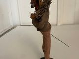 figurine of a man with a hat on his head and a chain around his neck