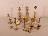 many different types of candles and candlesticks on the table