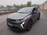 une voiture grise garée sur le bord de la route, à côté d'un parking