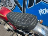 une moto rouge garée devant un mur recouvert de graffitis