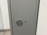 La porte d'un coffre-fort est ouverte dans un coin de la pièce.