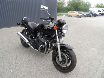 a black motorcycle parked in a parking lot next to a building