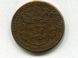 une vieille pièce de monnaie sur laquelle figure un blason, sur un fond blanc