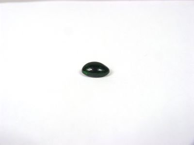 un gros plan d'une pierre de jade verte sur une surface blanche