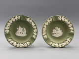 pair of green and white plates with figures on them
