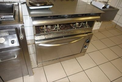 une cuisinière et un four dans une cuisine au sol carrelé