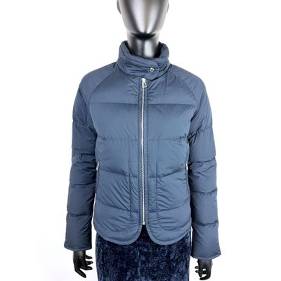 Le mannequin porte une veste bleue et une jupe noire.
