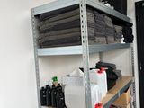 a room with a desk, shelves, and a chair