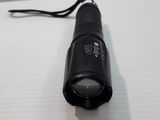 a black flashlight that is sitting on a white surface