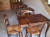 tables and chairs in a room with a staircase in the background