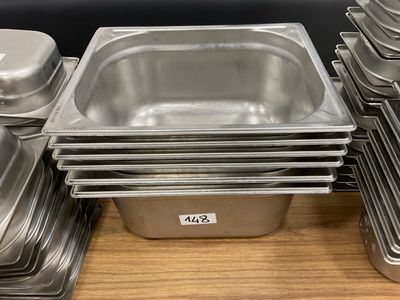 many trays of food sitting on a wooden table