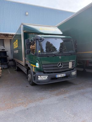 deux camions garés l'un à côté de l'autre devant un immeuble
