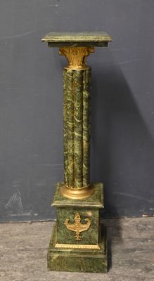a green marble pedestal with a bird on it