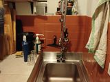 a sink in the corner of a kitchen with a towel hanging on the wall