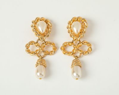 a pair of gold earrings with pearls on a white background