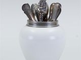 a white vase with spoons and spoons in it