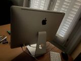 a computer monitor and keyboard on a desk in front of a window