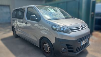 une camionnette Citroën garée devant un immeuble, sur un parking