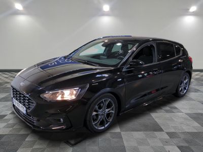Une Ford Focus noire est garée dans une pièce dont le sol est en damier.