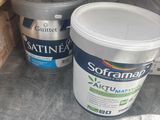 two buckets of paint sitting on the floor next to each other