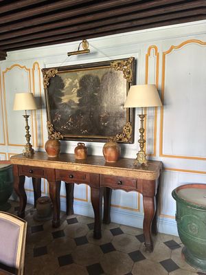 un tableau accroché au mur au-dessus d'une table dans une pièce
