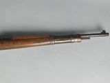 an old gun with a wooden handle on a white surface