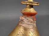 a gold vase with a red top sitting on a table
