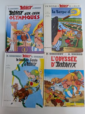 quatre albums de bandes dessinées posés sur une table, sur fond blanc