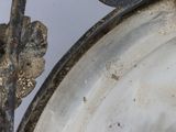 a close up of a metal object with a leaf on it