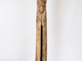 une vieille statue en bois représentant une personne au long cou