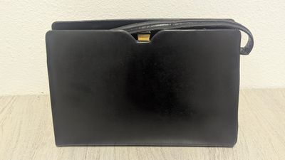 a black purse sitting on top of a wooden table